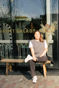 Nicole Perlman, Sales & Operations Manager at Mandy's Salads. She is sitting on a bench outside of the Yorkville location