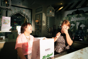 An employee and a manager at Mandy's laughing behind the counter.
