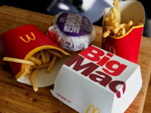 McDonald's fries, Big Mac, and burger on a wooden table.